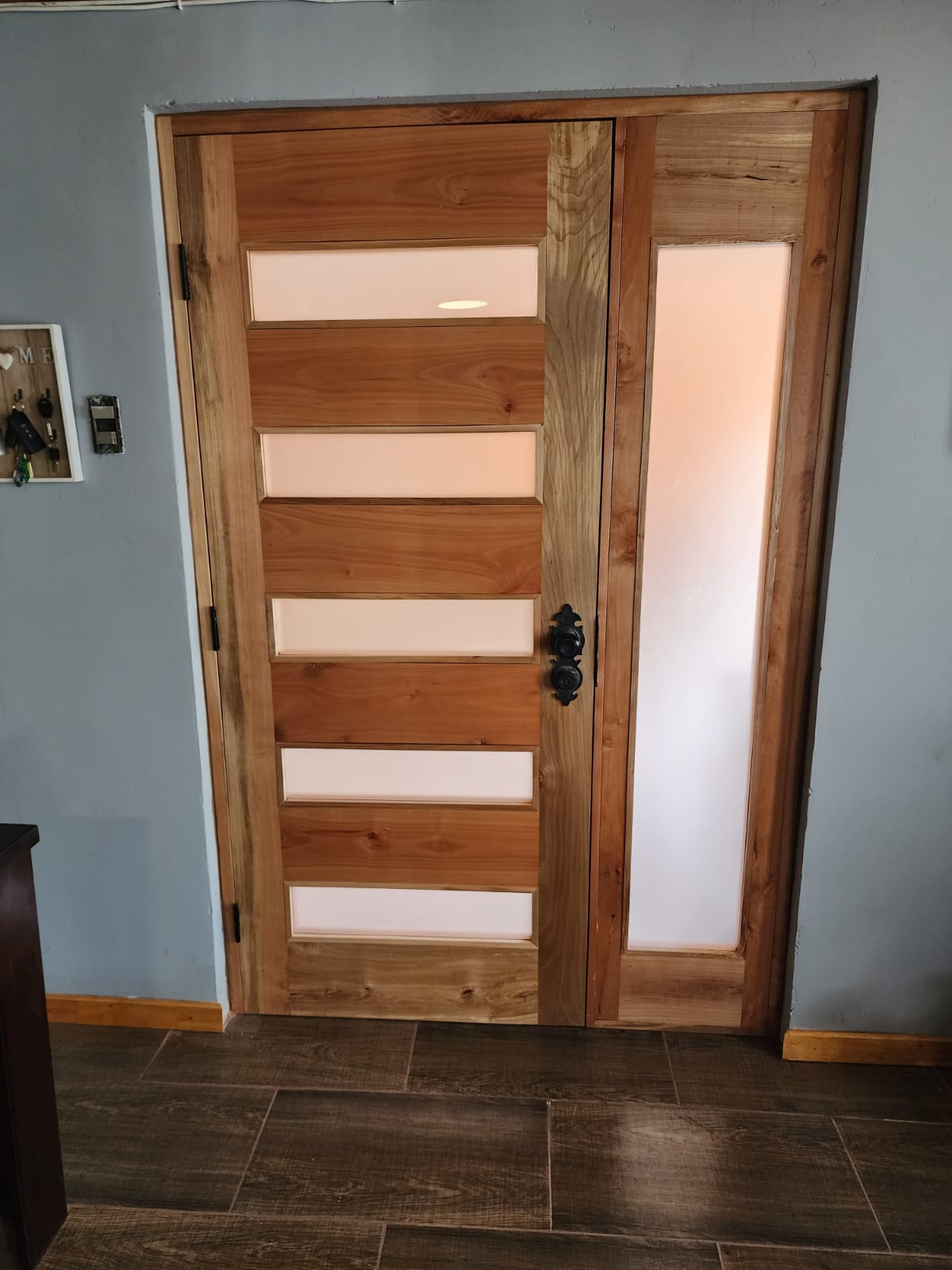 Puerta de entrada en madera nativa con vidrio